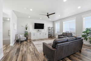 Living room with recessed lighting, dark wood-type flooring, and a ceiling fan
