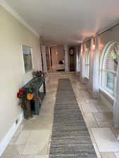 Hall with stone tile floors and baseboards