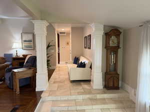 Hallway with decorative columns and stone tile flooring