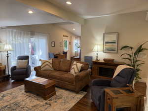 Living room with wood finished floors, recessed lighting, and a fireplace