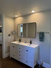 Bathroom with dark wood  flooring, double vanity, and recessed lighting
