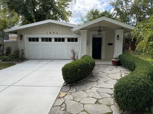 View of front of home with board and batten siding, concrete driveway, and a garage