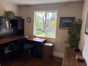 Home office with dark wood  flooring and baseboards