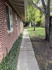 View of green lawn with back-yard walkway.