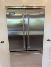 Detailed view of stainless steel Viking built in fridge and white cabinets