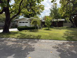 View of front facade featuring concrete driveway and a garage