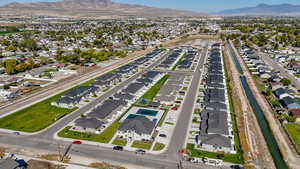 Aerial view of property and surrounding area with nearby suburban area and mountains