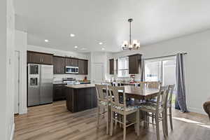 Dining room with light wood-style flooring, recessed lighting, and a chandelier