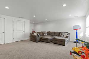 Living area featuring light carpet and recessed lighting