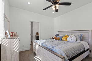 Bedroom with dark colored carpet, recessed lighting, ceiling fan, and connected bathroom