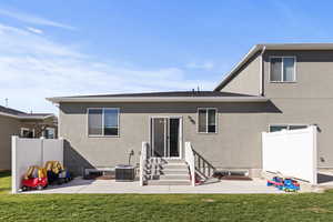 Rear view of property with stucco siding, entry steps, and a patio