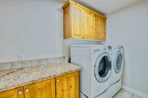Laundry room with counter space and cabinets.