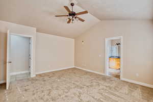 Primary bedroom featuring lofted ceiling, carpet flooring, and a ceiling fan