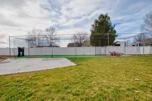 View of batting cage and additional concrete slab for building or RV parking.
