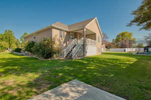 Back of house with stairs, stucco siding, and a playground