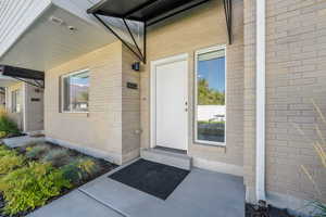 Doorway to property featuring brick siding
