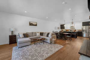 Living room featuring light wood-style floors, a textured ceiling, and recessed lighting