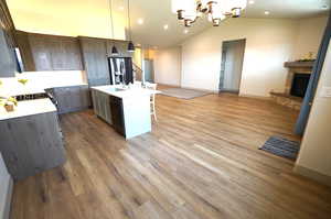 Kitchen with open floor plan, decorative light fixtures, a breakfast bar area, recessed lighting, and vaulted ceiling