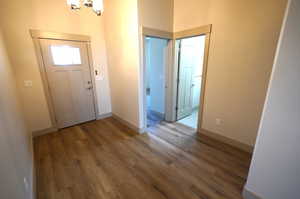 Foyer with dark wood-style floors and a chandelier