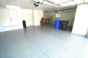 Garage with freestanding refrigerator and a garage door opener