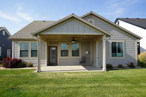 Back of property featuring a ceiling fan, a lawn, a patio area, and a shingled roof