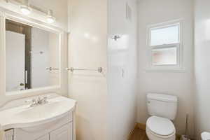 Half bath with vanity and wood finished floors