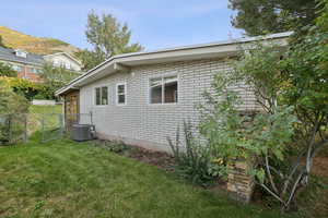 View of side of property featuring brick siding and a gate