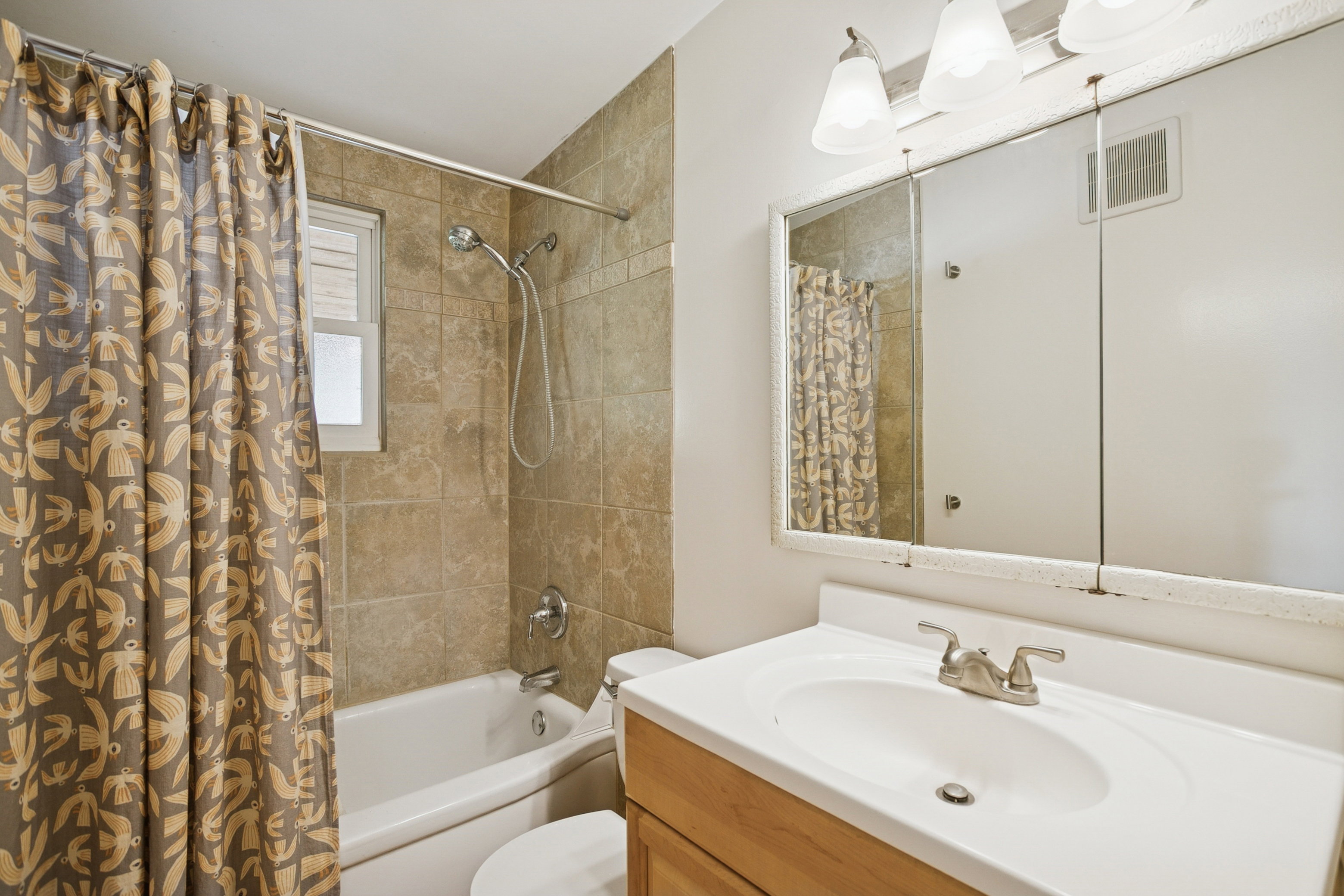 Bathroom featuring shower / tub combo and vanity