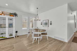 Dining area featuring light wood-style floors and a chandelier