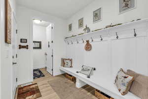 Mudroom featuring light wood-type flooring and baseboards