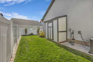 Fenced backyard featuring a storage unit
