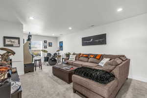 Living room featuring light colored carpet, recessed lighting, and a textured ceiling