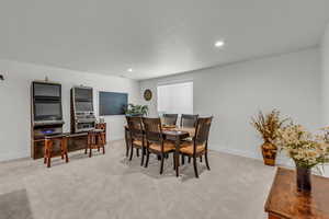 Dining area with light carpet and recessed lighting