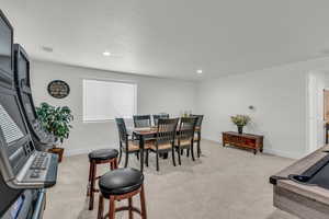 Dining area featuring light colored carpet, recessed lighting, and a textured ceiling