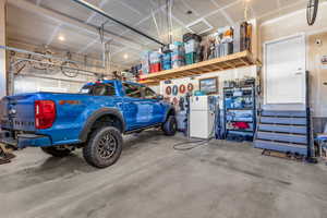 Garage featuring freestanding refrigerator and a garage door opener