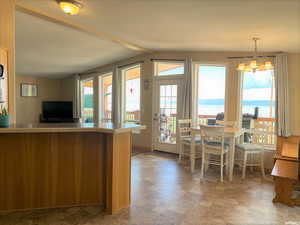 Kitchen with a water view, hanging light fixtures, a chandelier, light countertops, and stone finish flooring