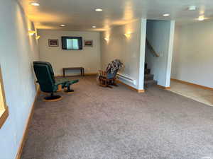 Living area featuring recessed lighting, carpet, baseboard heating, and stairway