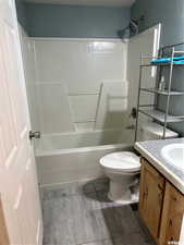 Full bathroom with shower / bathtub combination, vanity, and light wood finished floors