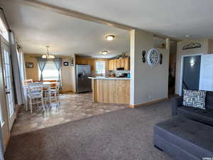 Living room featuring light carpet, vaulted ceiling, and a chandelier