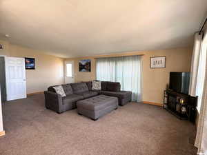Carpeted living area with baseboards