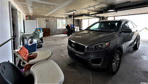 Garage with freestanding refrigerator and a garage door opener