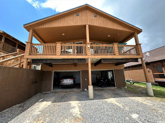 Rear view of house with driveway and a carport