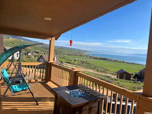 Deck with a fire pit, a water view, and a view of countryside