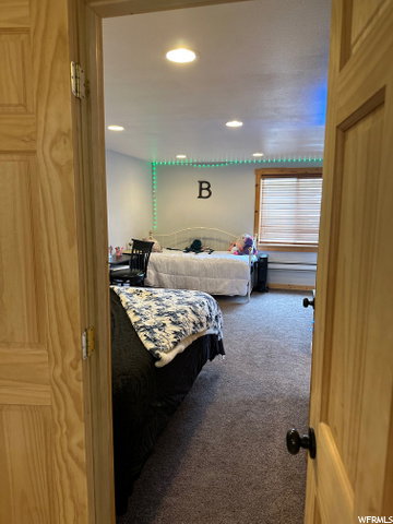 Carpeted bedroom with recessed lighting