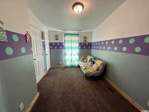 Unfurnished bedroom with dark carpet and a textured wall