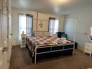Bedroom featuring dark colored carpet, a closet, and a textured ceiling
