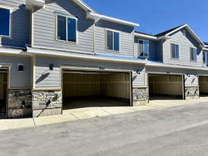 View of property exterior with stone siding and an attached garage