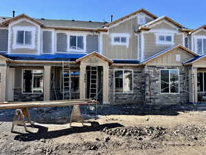 Rear view of property featuring stone siding and board and batten siding
