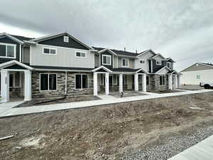 Craftsman-style house featuring stone siding, board and batten siding, and a porch