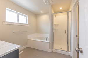 Bathroom featuring vanity, a bath, a shower stall, light tile patterned floors, and recessed lighting